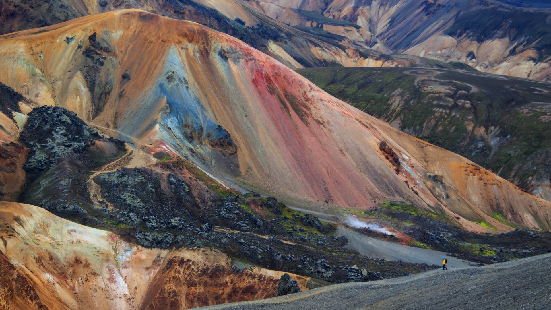 Hiker and colourful mountains in Landmannalaugar, Iceland