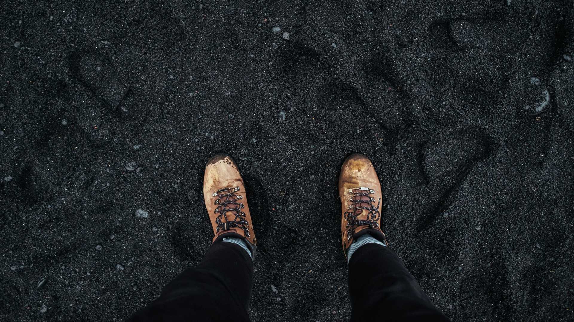 Hiking boots on a black sand beach in Iceland