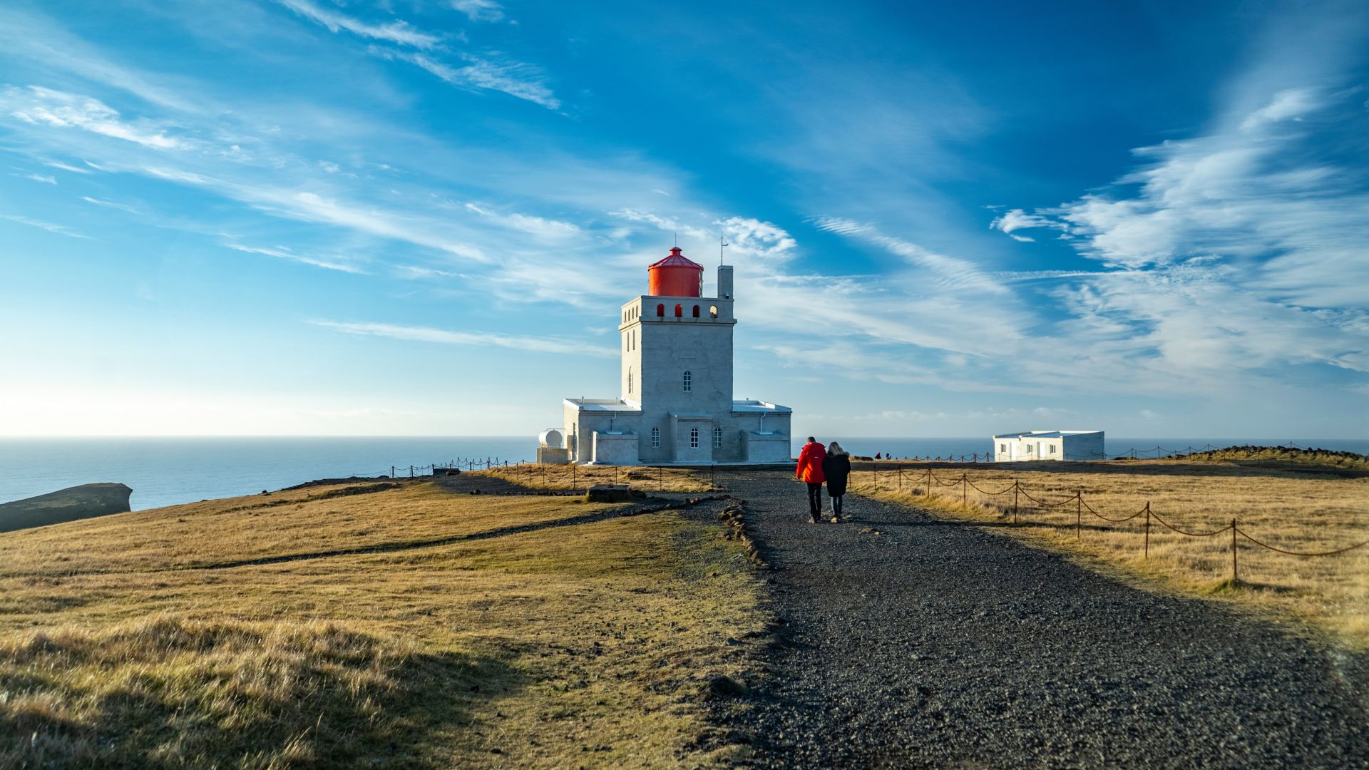 Couple walking towards Dyrhólaey Lighthouse, Iceland