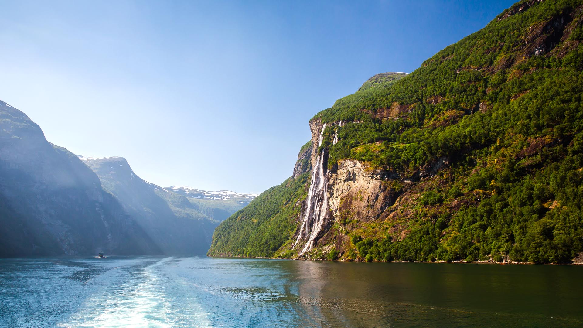 boat sailing along geirangerfjord