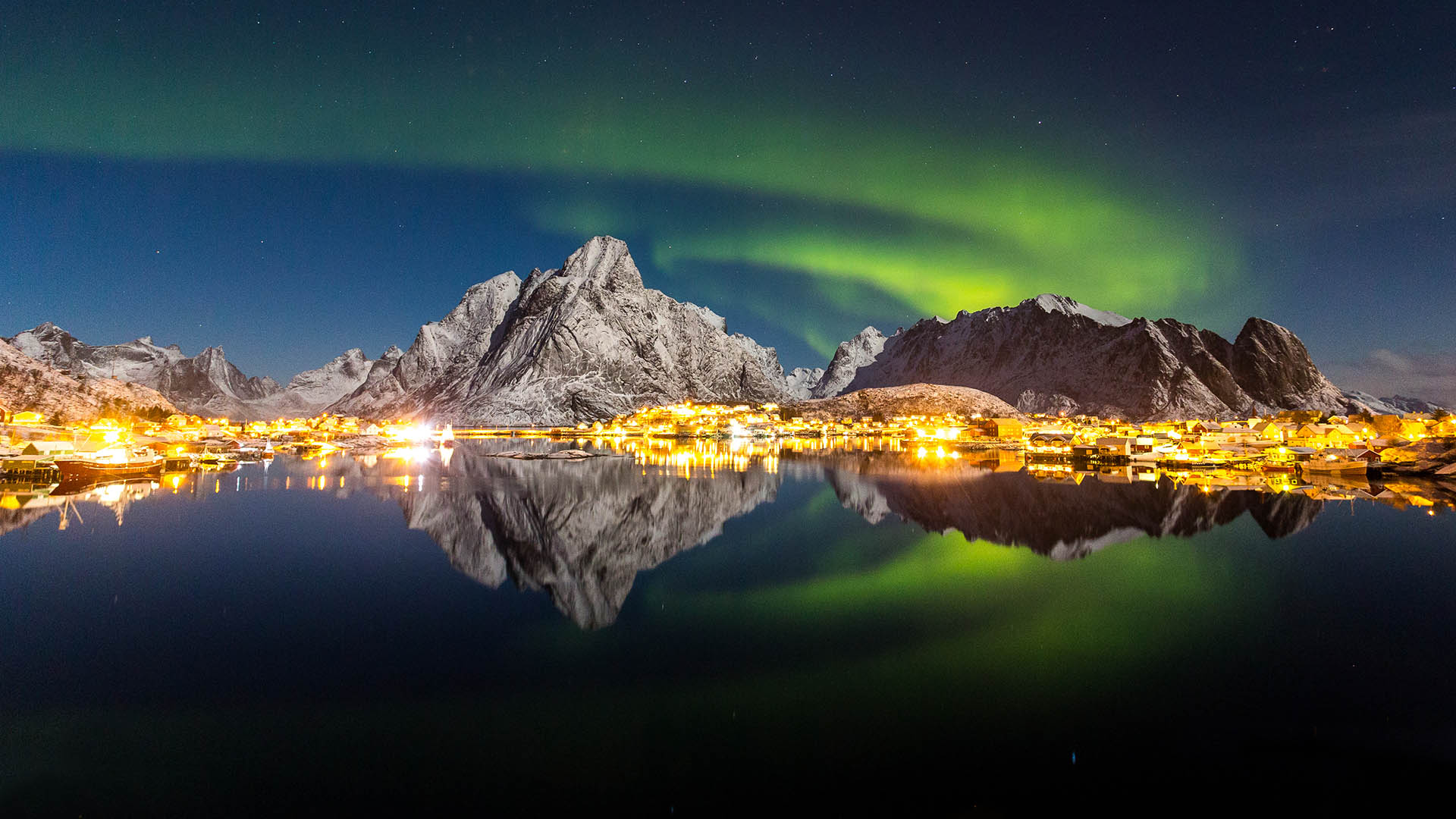 northern lights over town and mountains