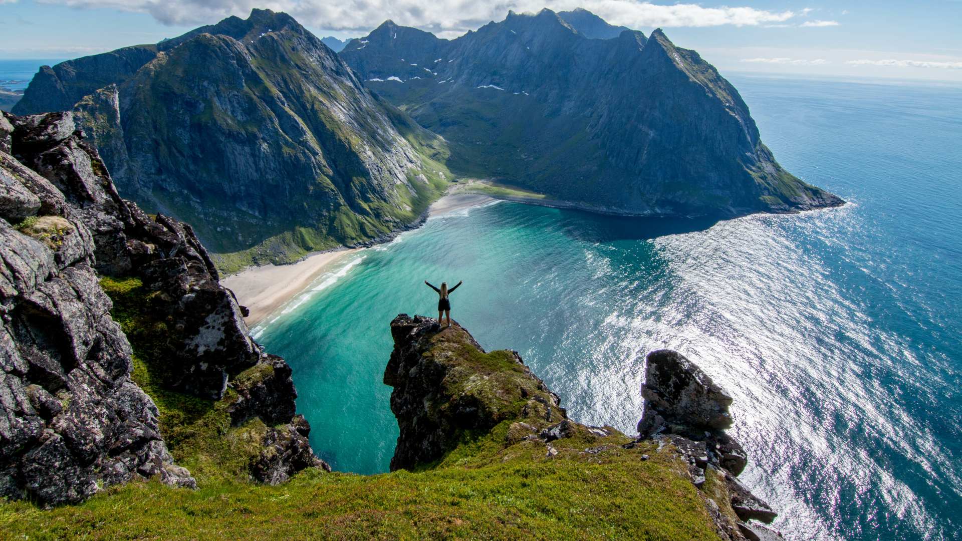 Person hiking above Kvalvika beach, Lofoten Islands, Norway