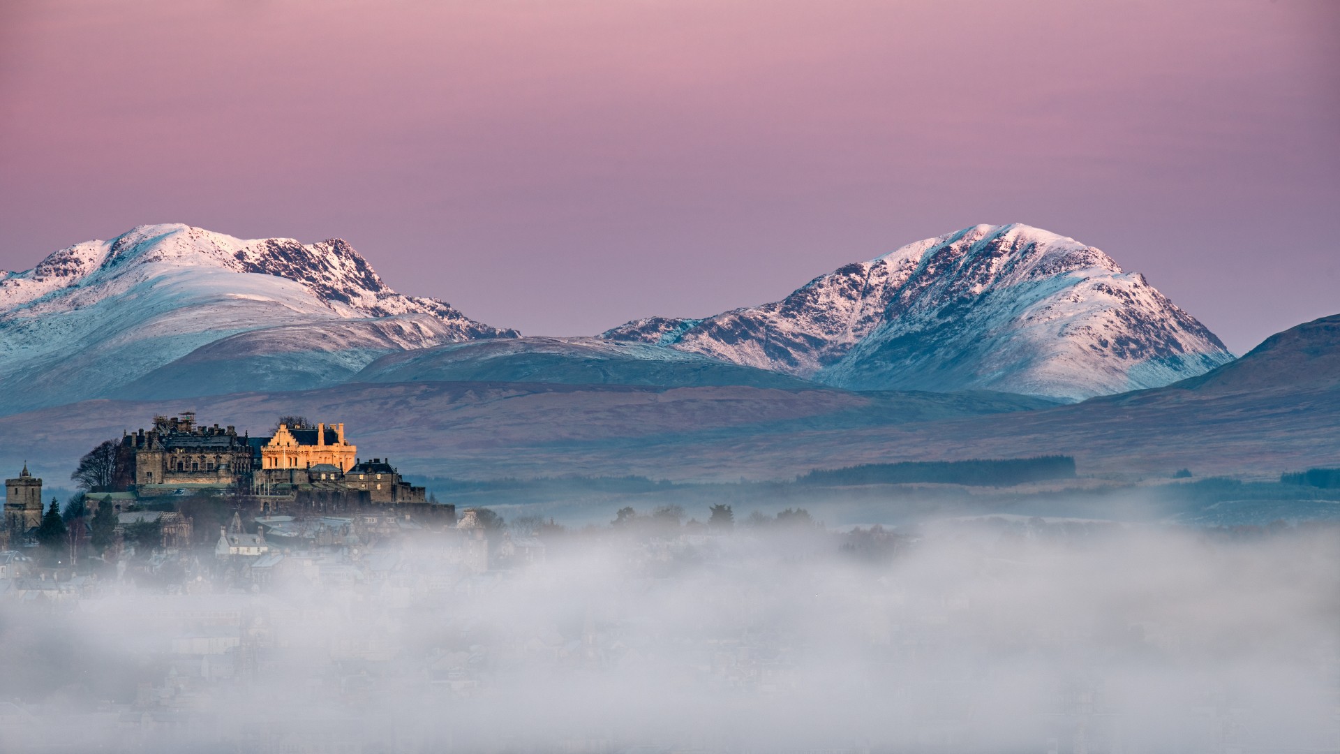 Stirling Castle at sunrise surrounded by mist.