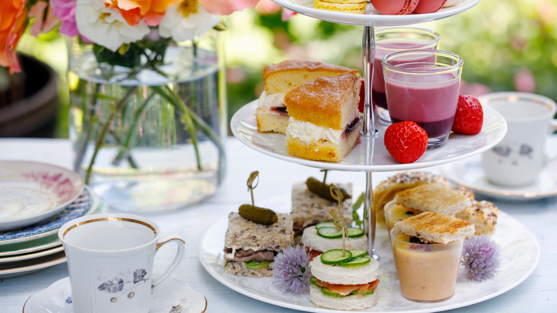 colourful afternoon tea with flowers sandwiches and cake